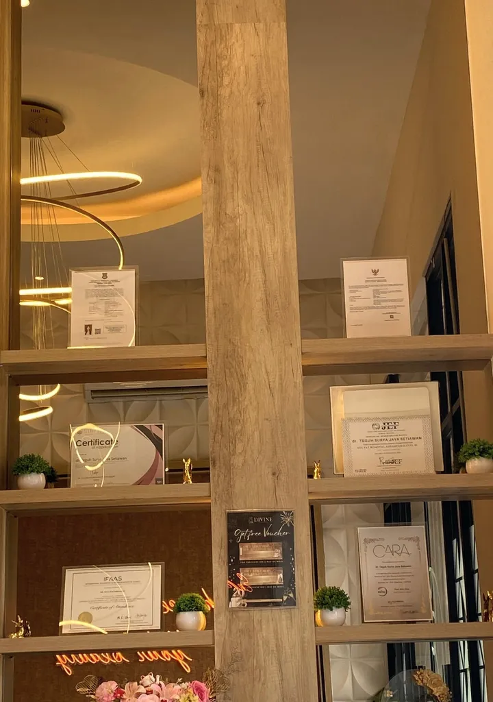 Rak kayu berisi sertifikat dan izin klinik di lobby
