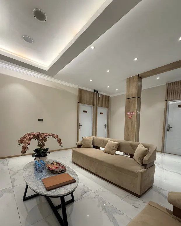 Lounge Divine dengan sofa beludru krem, meja marmer, dan anggrek