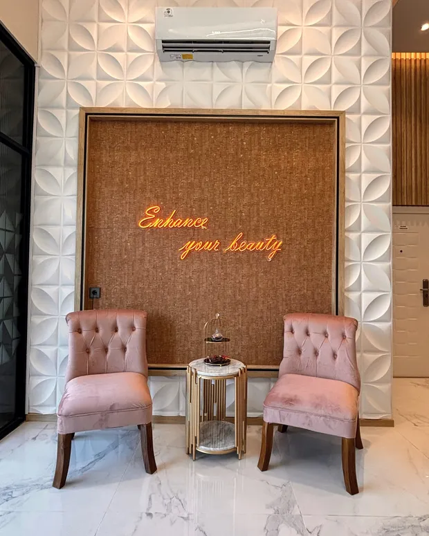 Sudut lounge Divine dengan kursi velvet blush dan neon Enhance your beauty