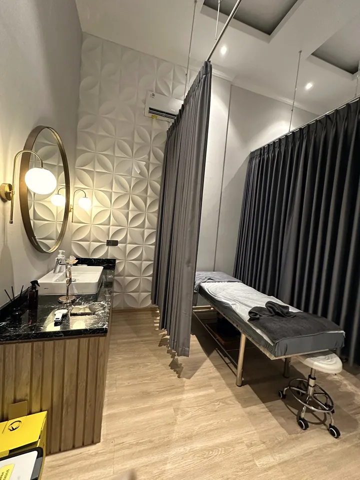 Bed tindakan dengan tirai privasi abu-abu dan wastafel marmer